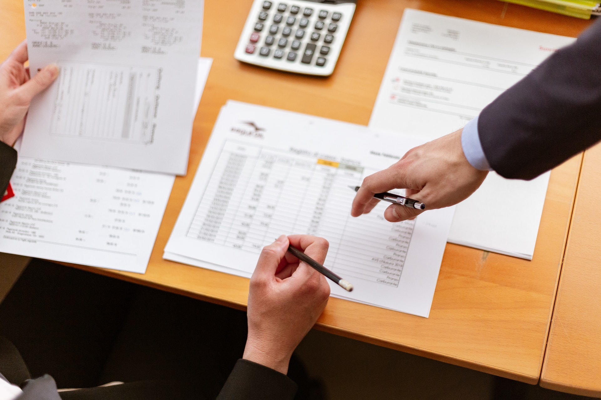 person reviewing graphs and charts on a desk