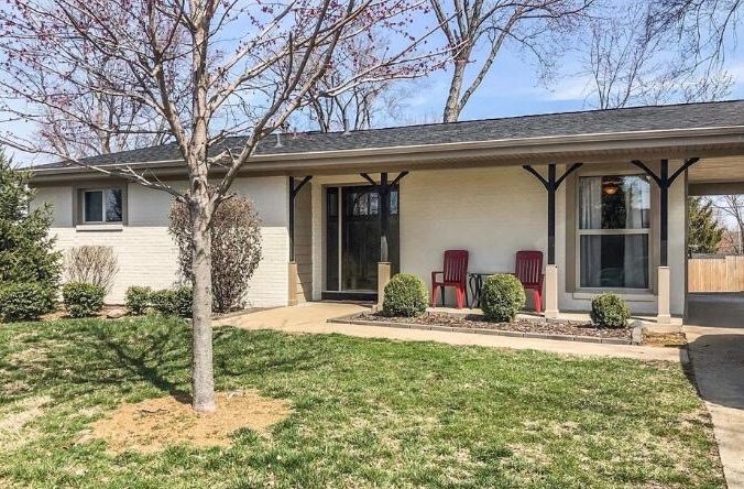 A white ranch house with a yard